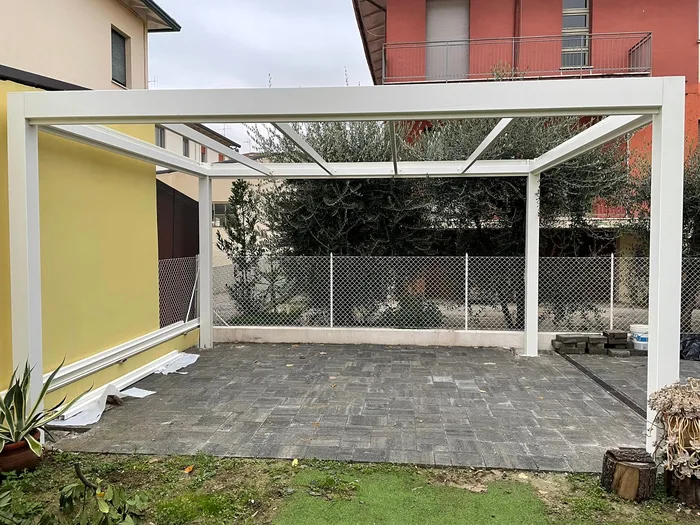 Chiusura per veranda con vetrate scorrevoli in alluminio bianco affacciata sul giardino