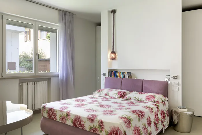 Camera da letto shabby chic con finestra in legno bianco e tessuti floreali