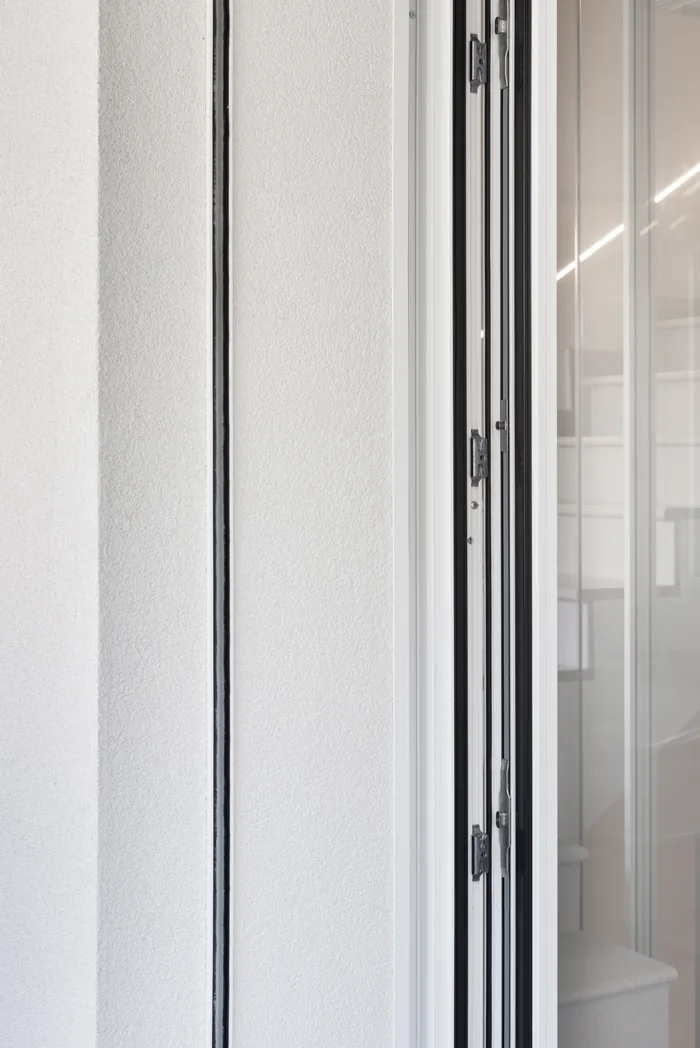 Dettaglio infisso bianco minimal con profilo a taglio termico, ferramenta multi-punto a scomparsa per sicurezza antieffrazione - Bisacchi