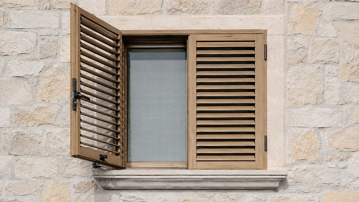 Persiane blindate alluminio effetto legno rovere chiaro su facciata pietra