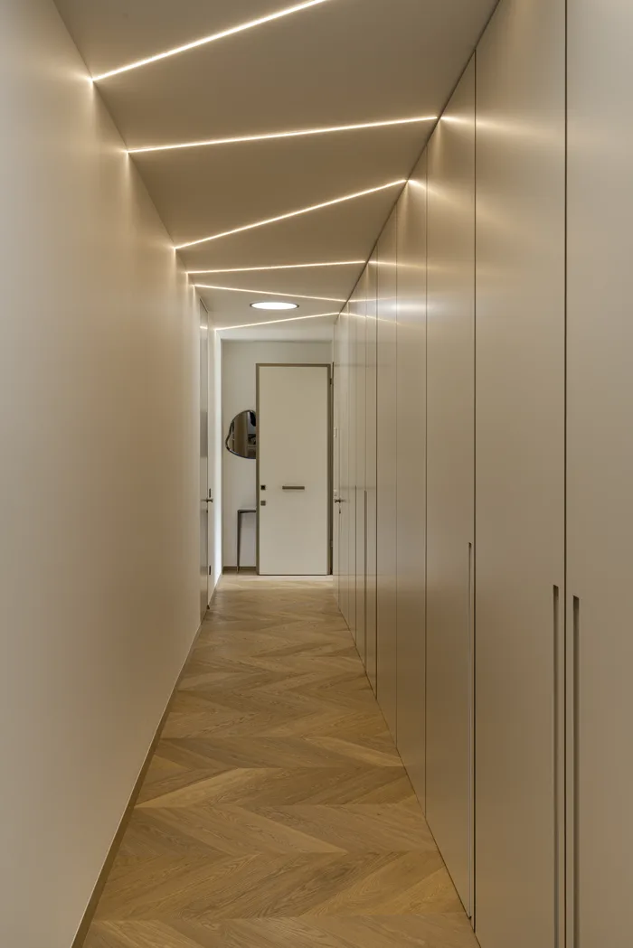 Corridoio di lusso con porta blindata filo muro bianca e parquet a spina di pesce - Bisacchi