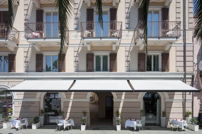 Tende da sole a bracci bianche sulla facciata di un hotel