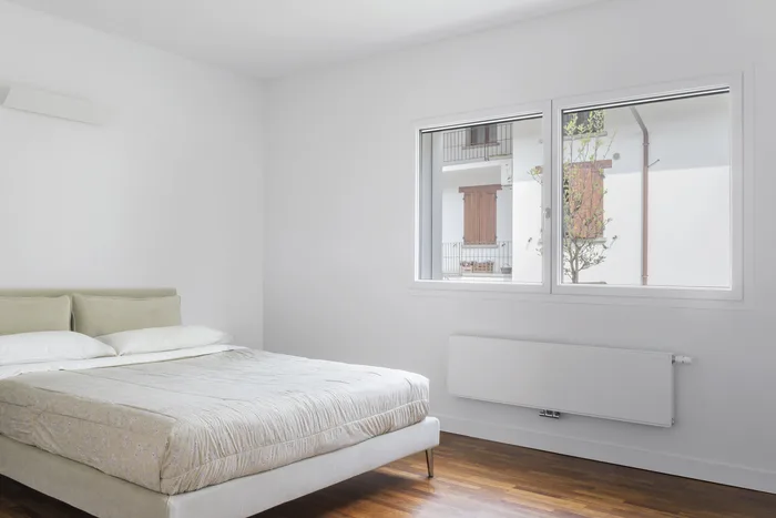 Camera da letto rilassante con pareti chiare e finestra che fa entrare luce naturale