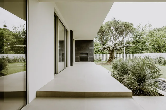 Terrazzo di attico con vista sui pini e cielo azzurro