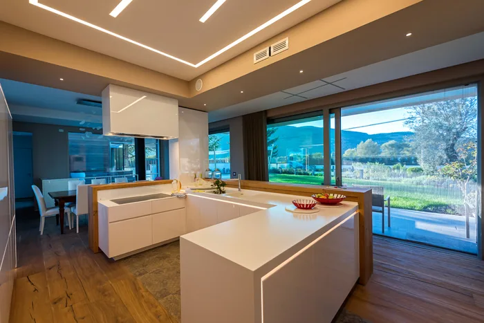 Design serramenti: interno di villa moderna con grandi vetrate scorrevoli minimali sul giardino