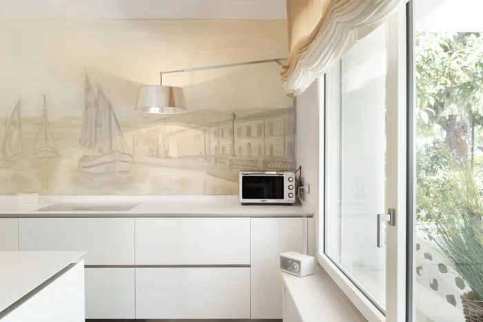 Finestra in legno-alluminio laccato bianco in cucina con vista giardino