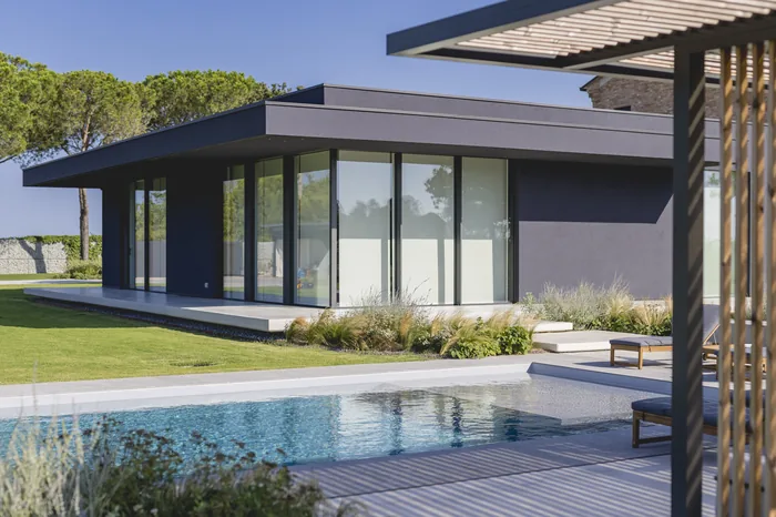 Villa con grandi finestre vetrate scorrevoli affacciate sulla piscina
