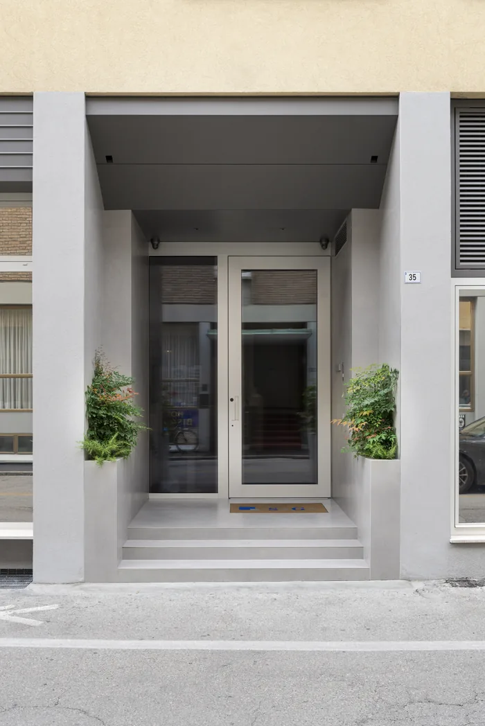 Porta blindata in alluminio grigia moderna installata sull'ingresso di una villa