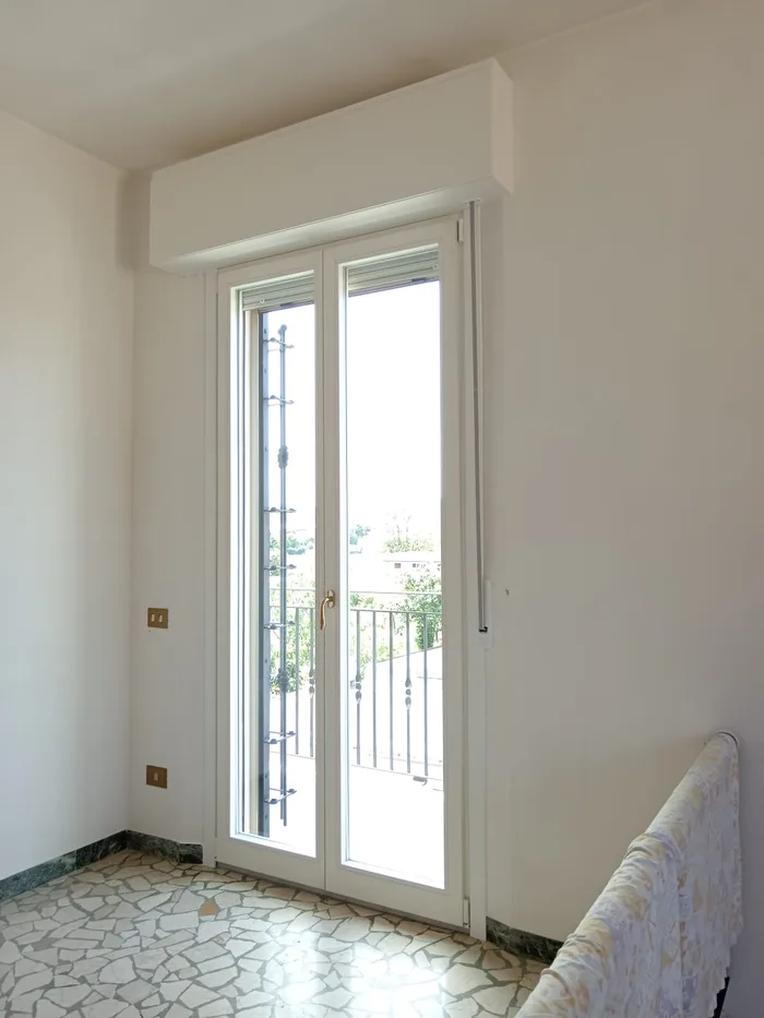 Inferriata apribile bianca su portafinestra vista dall'interno