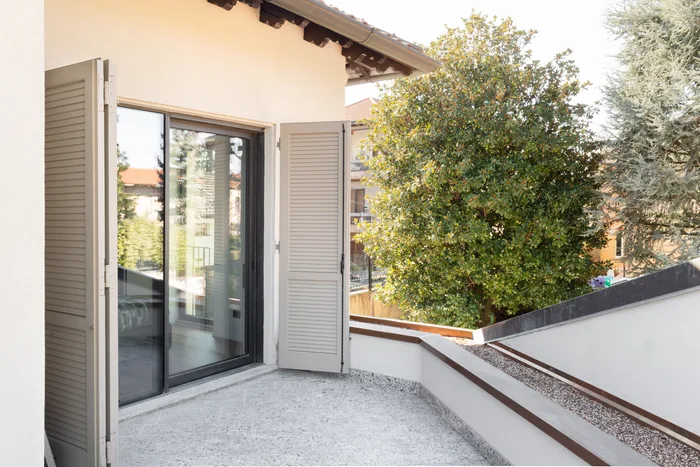 Porte finestre con scuri antracite su terrazzo di villa moderna