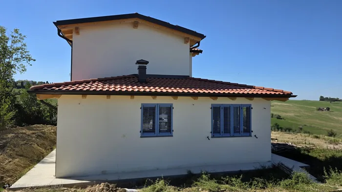 Villa rustica di campagna con facciata bianca e scuri blu in stile rustico