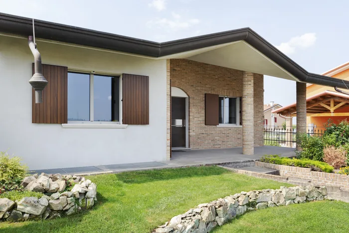 Ingresso di villa classica beige con porte finestre e scuri in stile classico