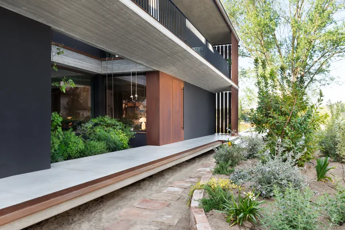 Porta d'ingresso non blindata in corten su una villa moderna con giardino