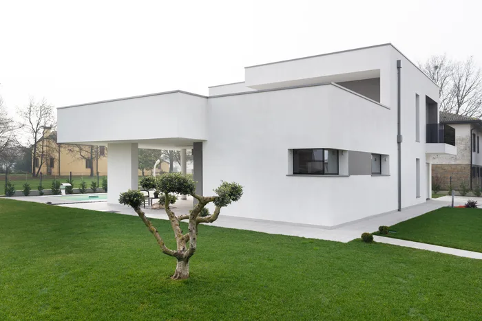 Serramenti di design con grandi vetrate su villa moderna bianca minimal con giardino