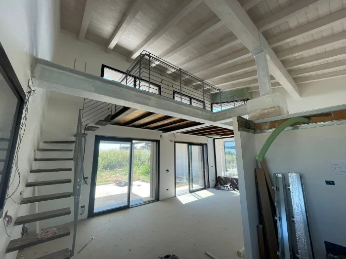 Soppalco calpestabile con scala e grandi vetrate in una casa luminosa