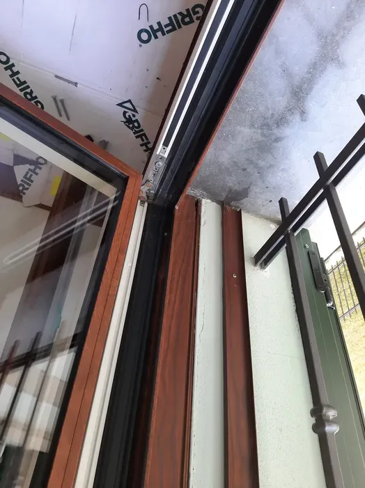 Dettaglio del telaio di un serramento in legno-alluminio con membrana di tenuta in posa