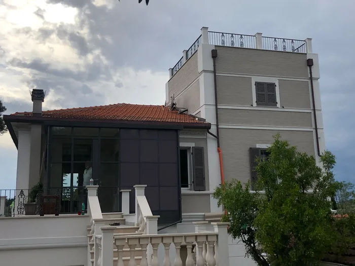 Veranda in terrazza vetrata antracite su terrazzo di villa classica