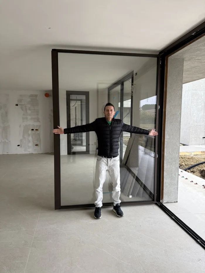William Bisacchi davanti a un grande serramento di design in una villa appena finita