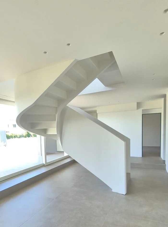 Creare soppalchi: scala scultorea in una villa moderna che porta al livello superiore