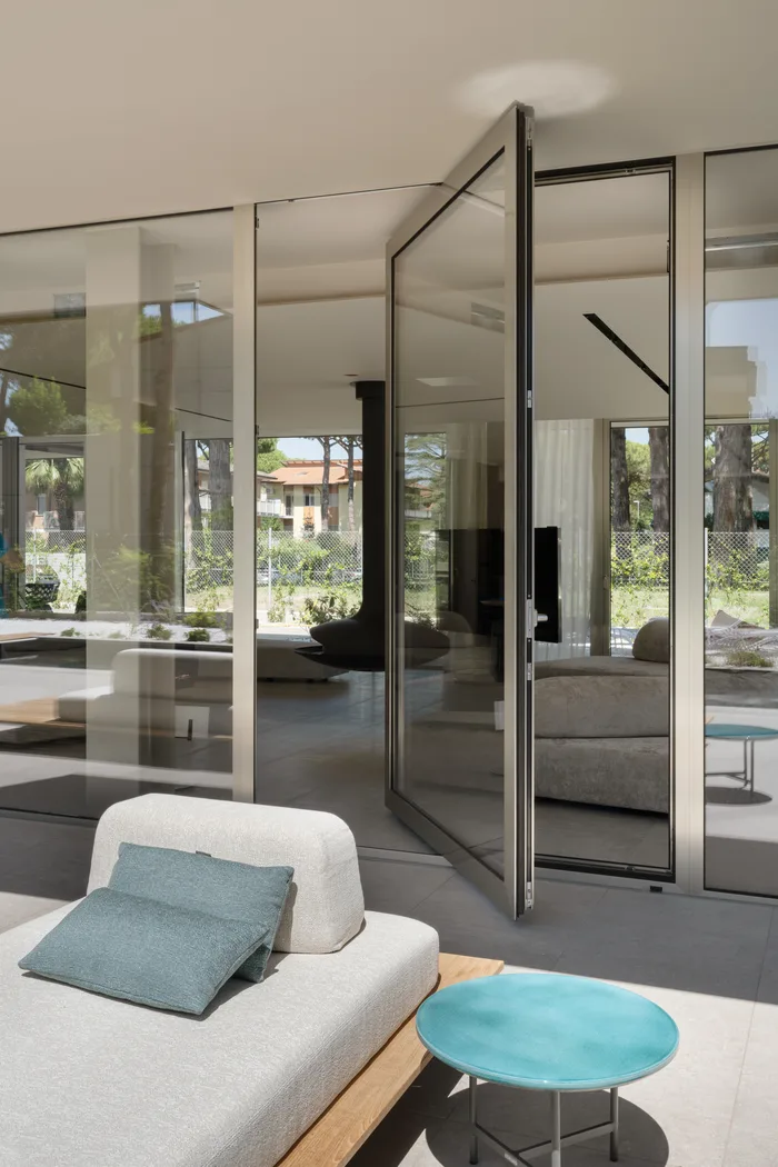 Vetrata a bilico verticale in alluminio senza cerniere a vista in una villa di lusso