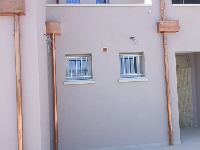 Inferriate classe 4 bianche fisse installate su due finestre di una facciata, sicurezza antieffrazione
