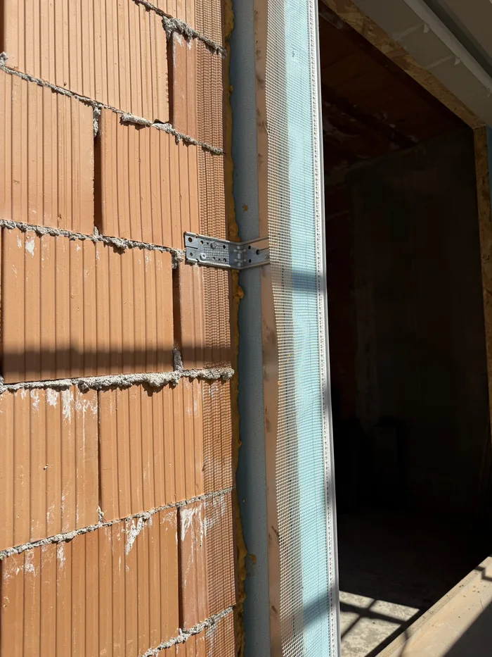 Infissi in PVC caratteristiche di posa: telaio bianco fissato con zanca su muro in laterizio
