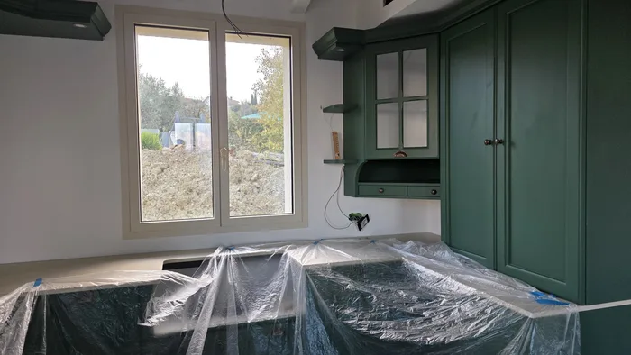 Manutenzione finestra in PVC: controllo di guarnizioni e ferramenta su serramento bianco in cantiere