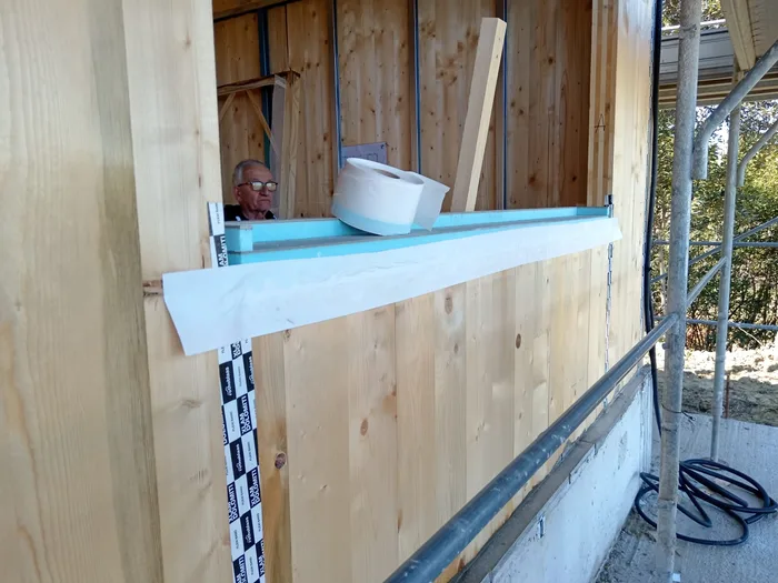 Posa di un monoblocco con cassonetto termoisolante in un cantiere di casa in legno