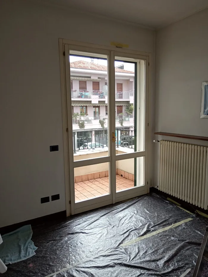Portafinestra bianca datata in un appartamento prima della sostituzione
