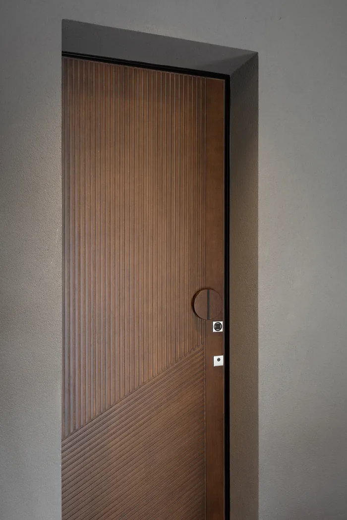 Dettaglio di porta blindata coibentata in legno noce con doghe verticali