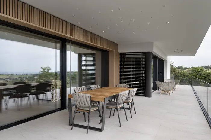 Proteggere la casa dal caldo: terrazza in ombra con frangisole e vetrate schermate