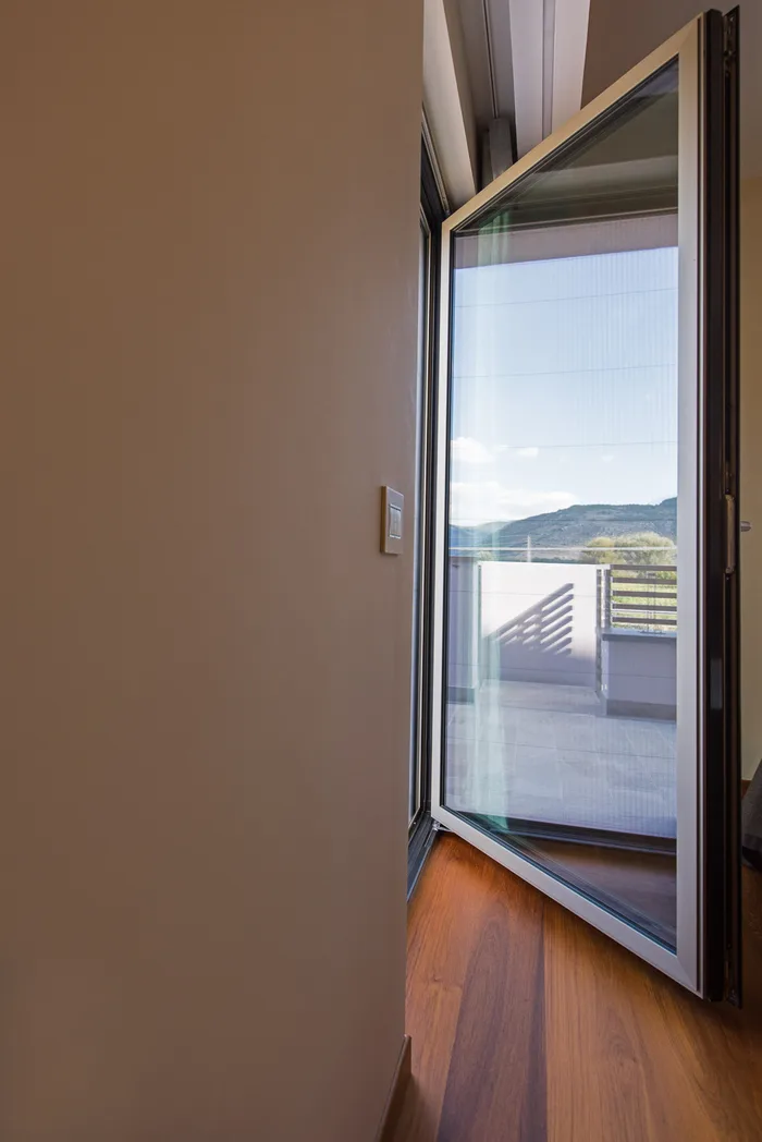 Portafinestra in alluminio antracite aperta sul terrazzo