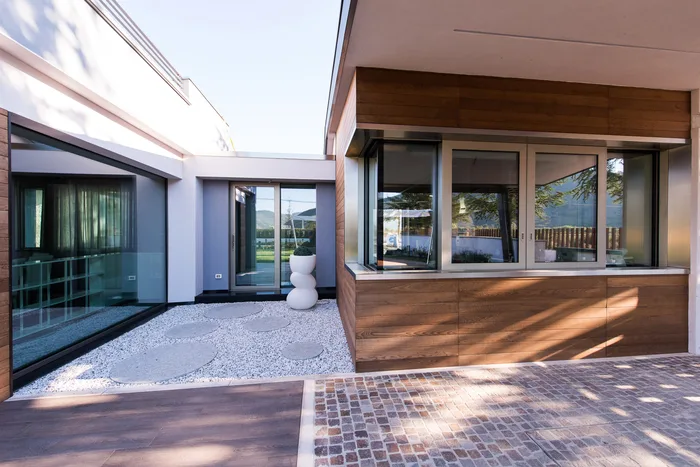 Serramenti di alta qualità: grandi finestre in alluminio color champagne su una villa moderna con rivestimento in legno