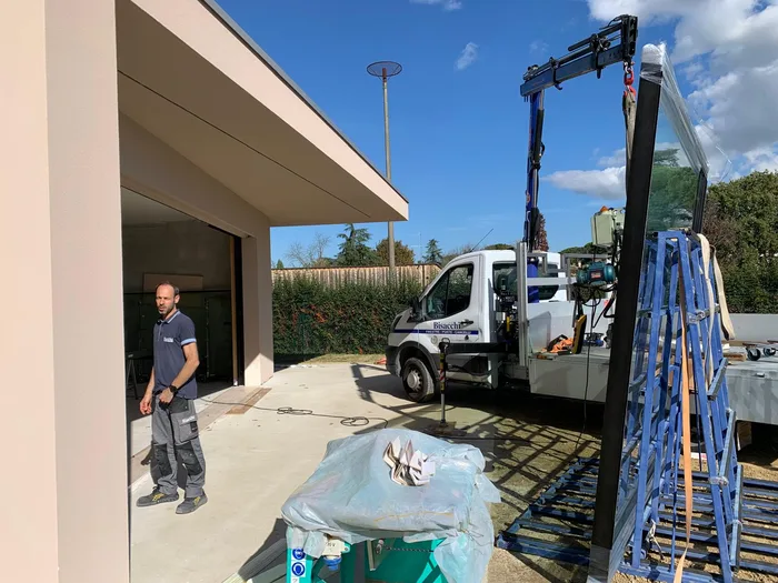 Operaio Bisacchi durante la consegna dei vetri in cantiere con gru