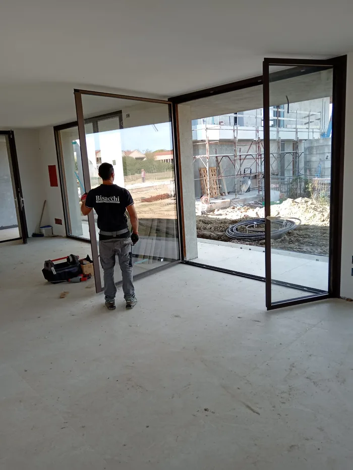 Operaio Bisacchi durante la posa di una vetrata ad angolo in cantiere