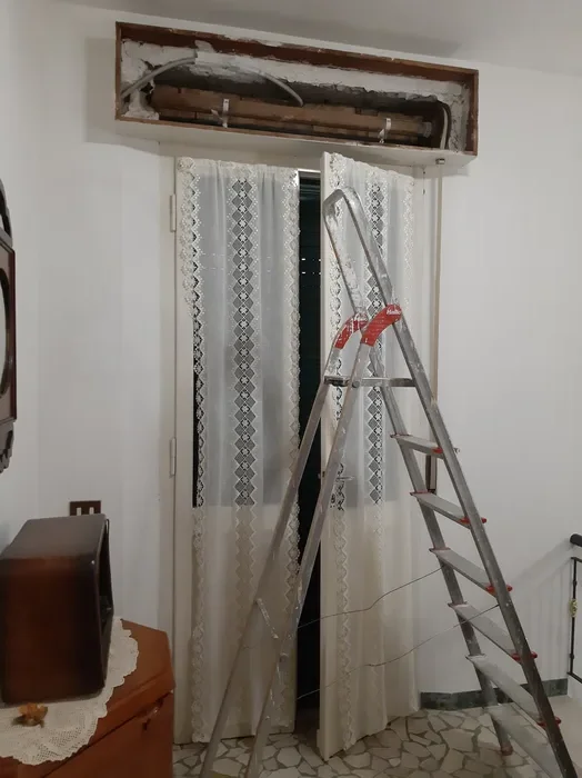Cassonetto aperto durante la sostituzione in un appartamento, con scala di lavoro