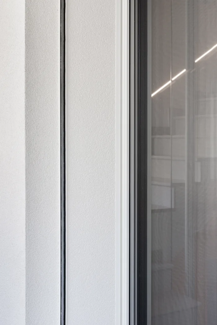 dettaglio del profilo di una zanzariera montata a filo su una finestra in alluminio