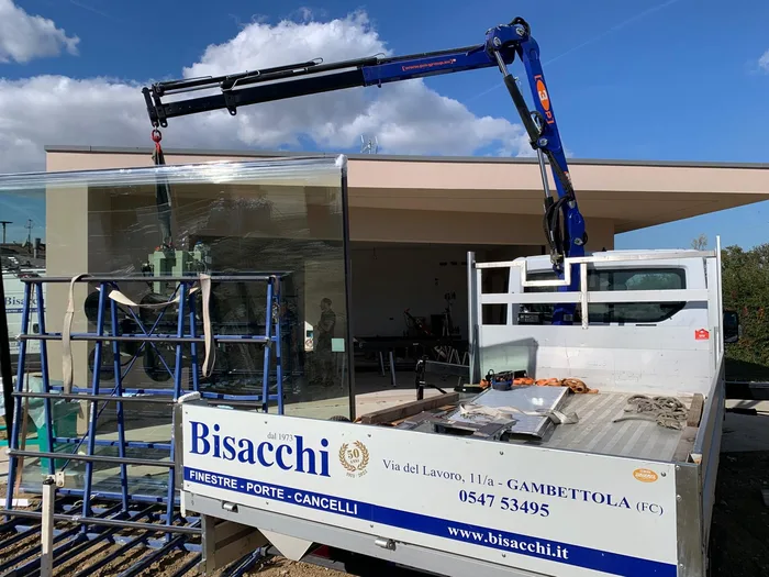Camion Bisacchi con gru durante la consegna di una vetrata in cantiere