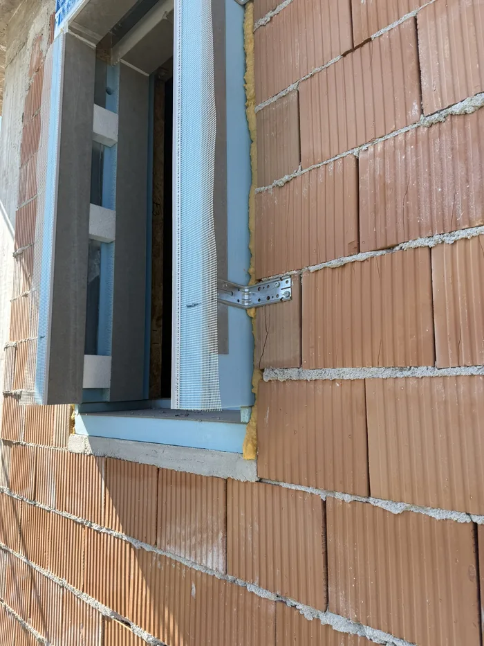 Telaio in laterizio con serramento posato e sigillature durante i lavori in cantiere
