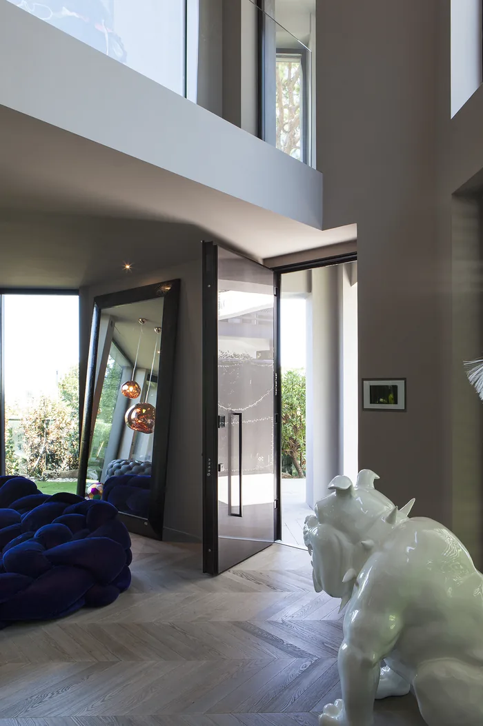 Villa moderna con rivestimento in legno e serramenti antracite affacciata sul giardino