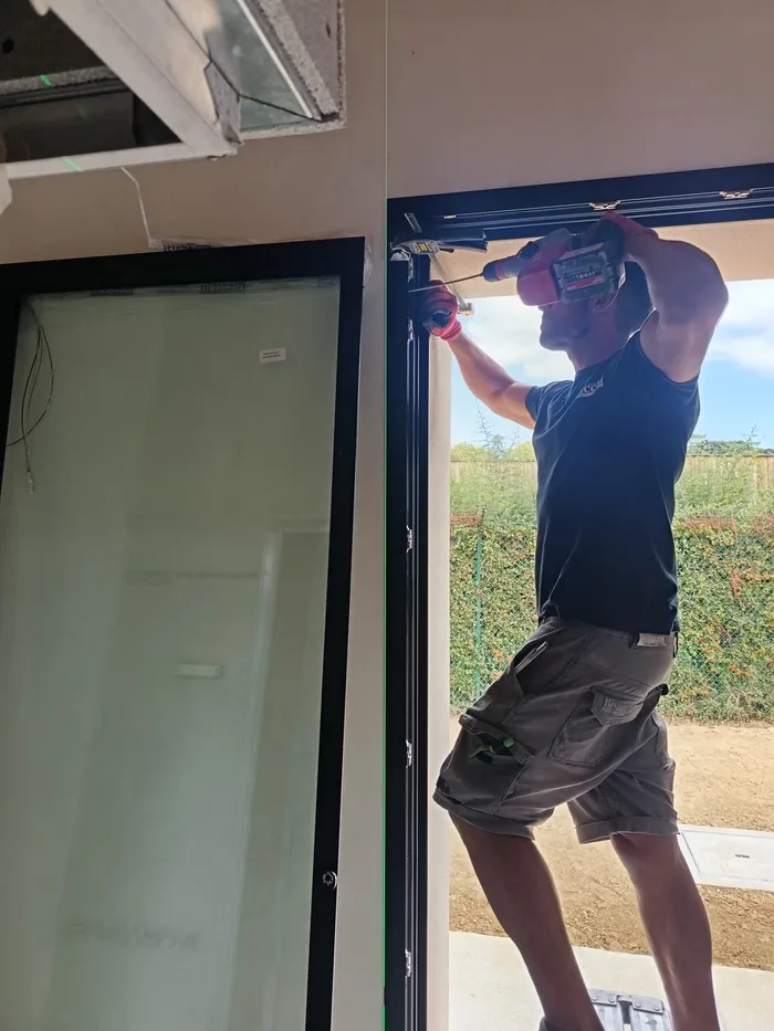 Operaio Bisacchi durante la posa di un serramento antracite in cantiere