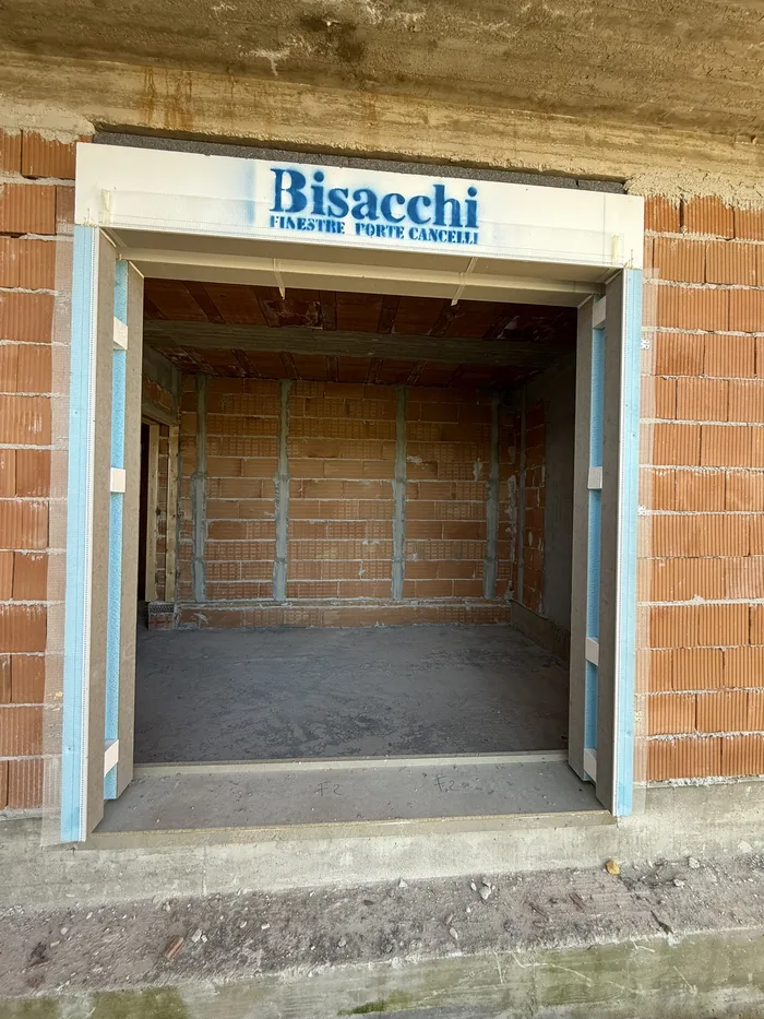 Vano finestra in laterizio con serramento e sigillature durante il controllo in cantiere