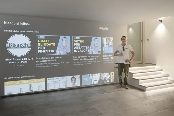 William Bisacchi nello showroom di Gambettola davanti al muro delle soluzioni infissi
