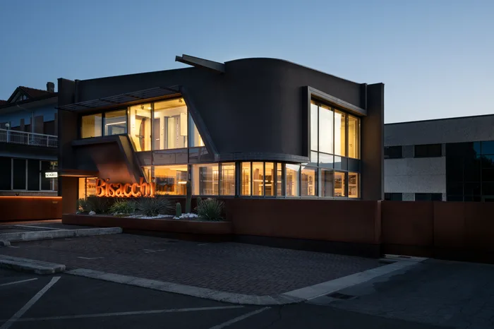 Facciata dello showroom Bisacchi illuminata di sera con le grandi vetrate