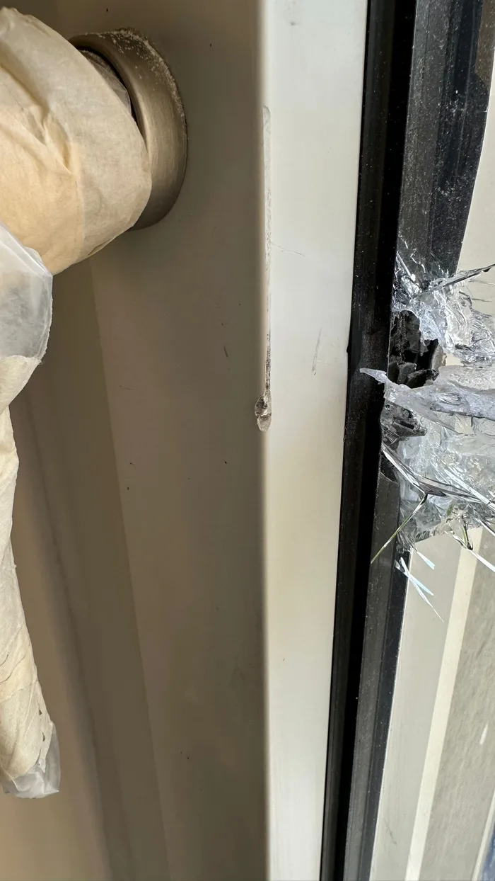 Vetro di una finestra fessurato dopo un urto, con i frammenti trattenuti dalla pellicola