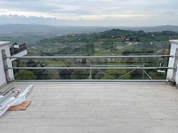 Parapetto in vetro stratificato di sicurezza su terrazzo panoramico verso la collina